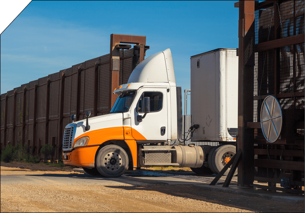 Full truckload transport truck at a cross-border facility, representing secure and reliable FTL shipping between Canada, the U.S., and Mexico.